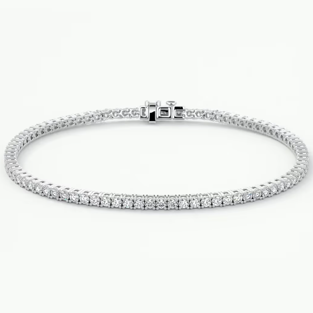 A white gold tennis bracelet with a row of clear round-cut stones along the front, displayed in a circular shape against a clean white background.