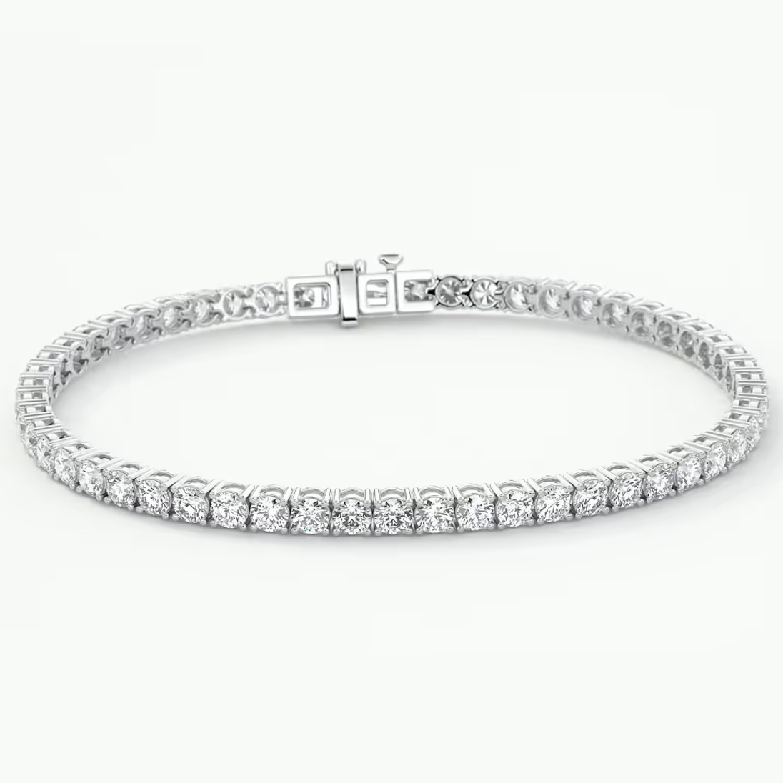 A white gold tennis bracelet with a row of round-cut clear gemstones, displayed on a clean white background.