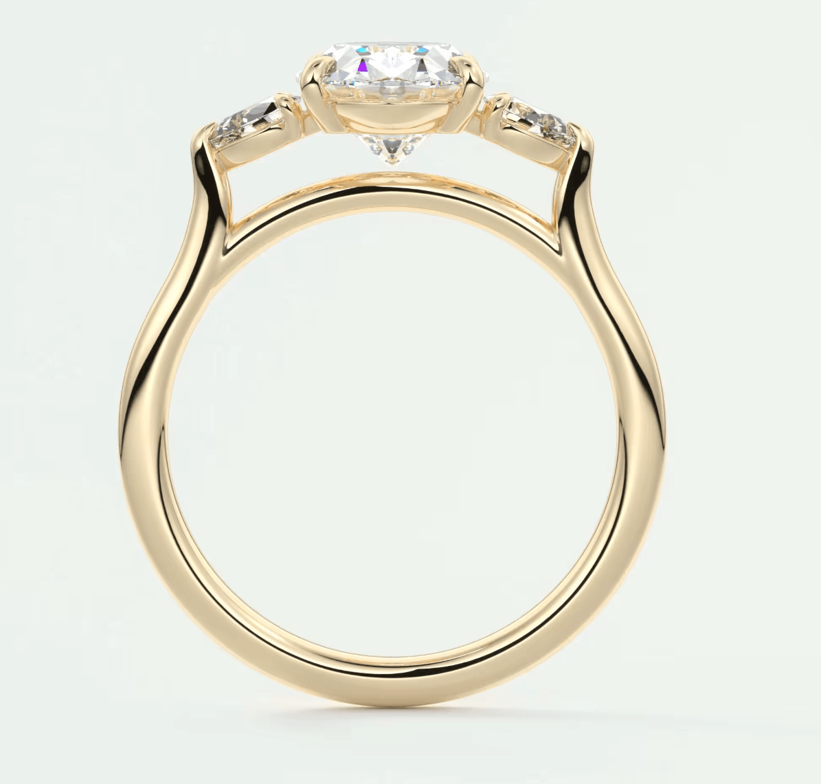 18k yellow gold engagement ring with a marquise-cut diamond and two smaller diamonds on either side.