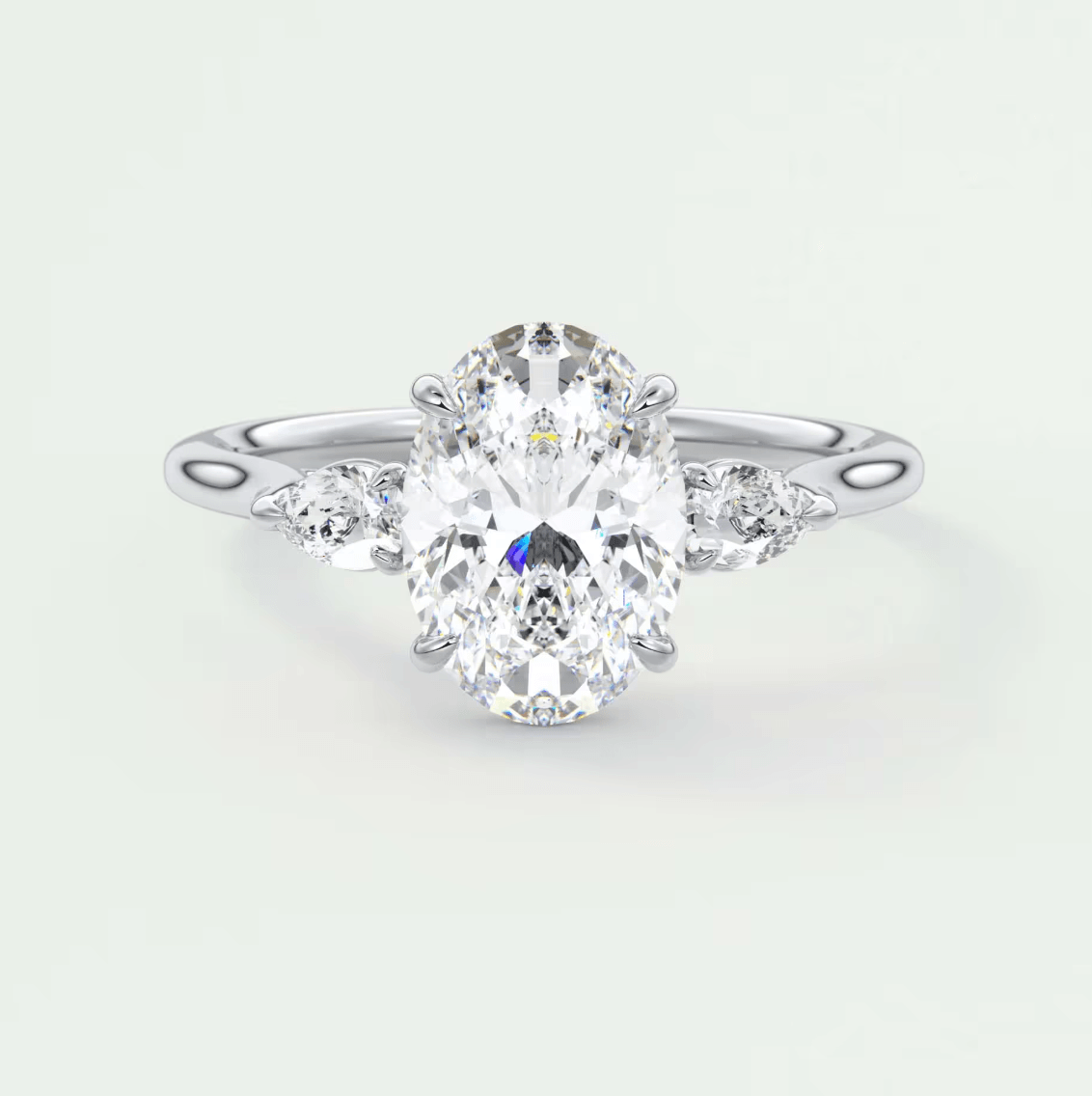 18k white gold oval diamond engagement ring with three smaller diamonds on each side.