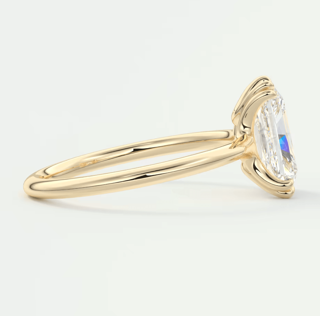 18k yellow gold engagement ring with a marquise-cut diamond and halo design.