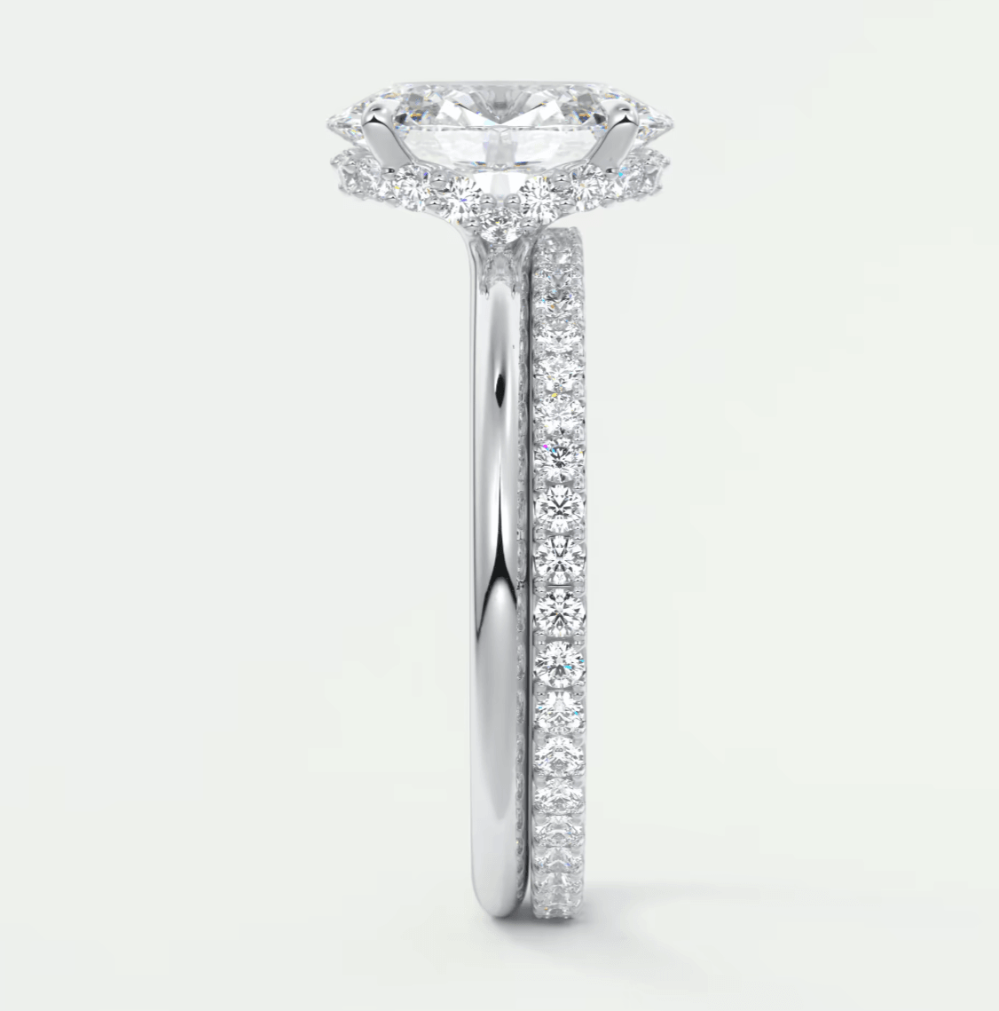 18-karat white gold engagement ring with a cushion-cut diamond center stone and pavé set diamonds on the band.