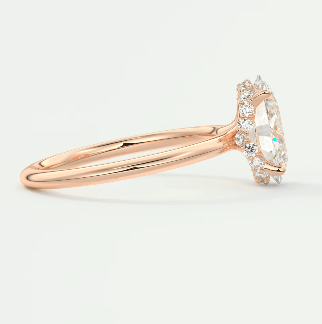 Rose gold marquise diamond engagement ring with halo detailing and small diamonds on band.