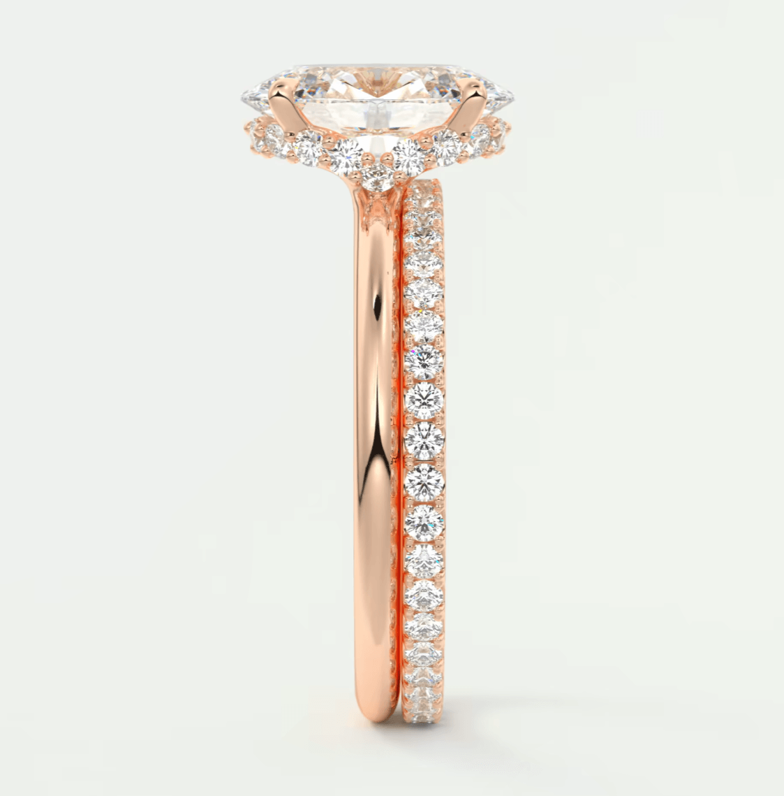 18-karat rose gold engagement ring with a cushion-cut diamond center and pavé set diamonds on the band.