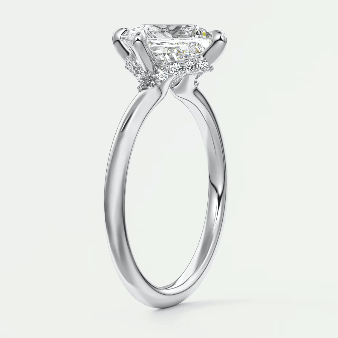 Princess cut diamond engagement ring with white gold band and diamonds on the sides.