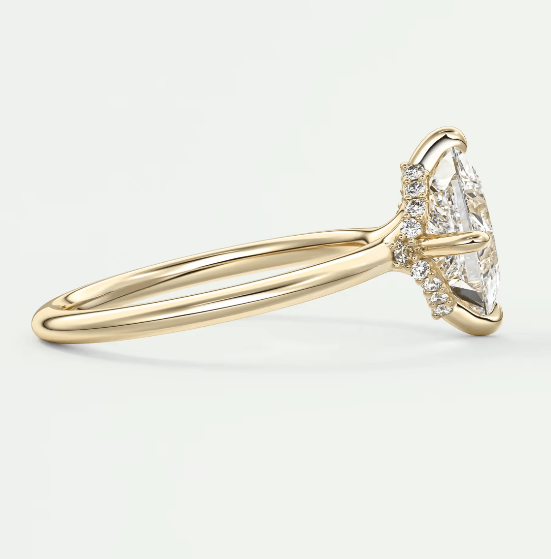 18k yellow gold diamond engagement ring with a marquise-cut center stone and small round diamonds on the band.