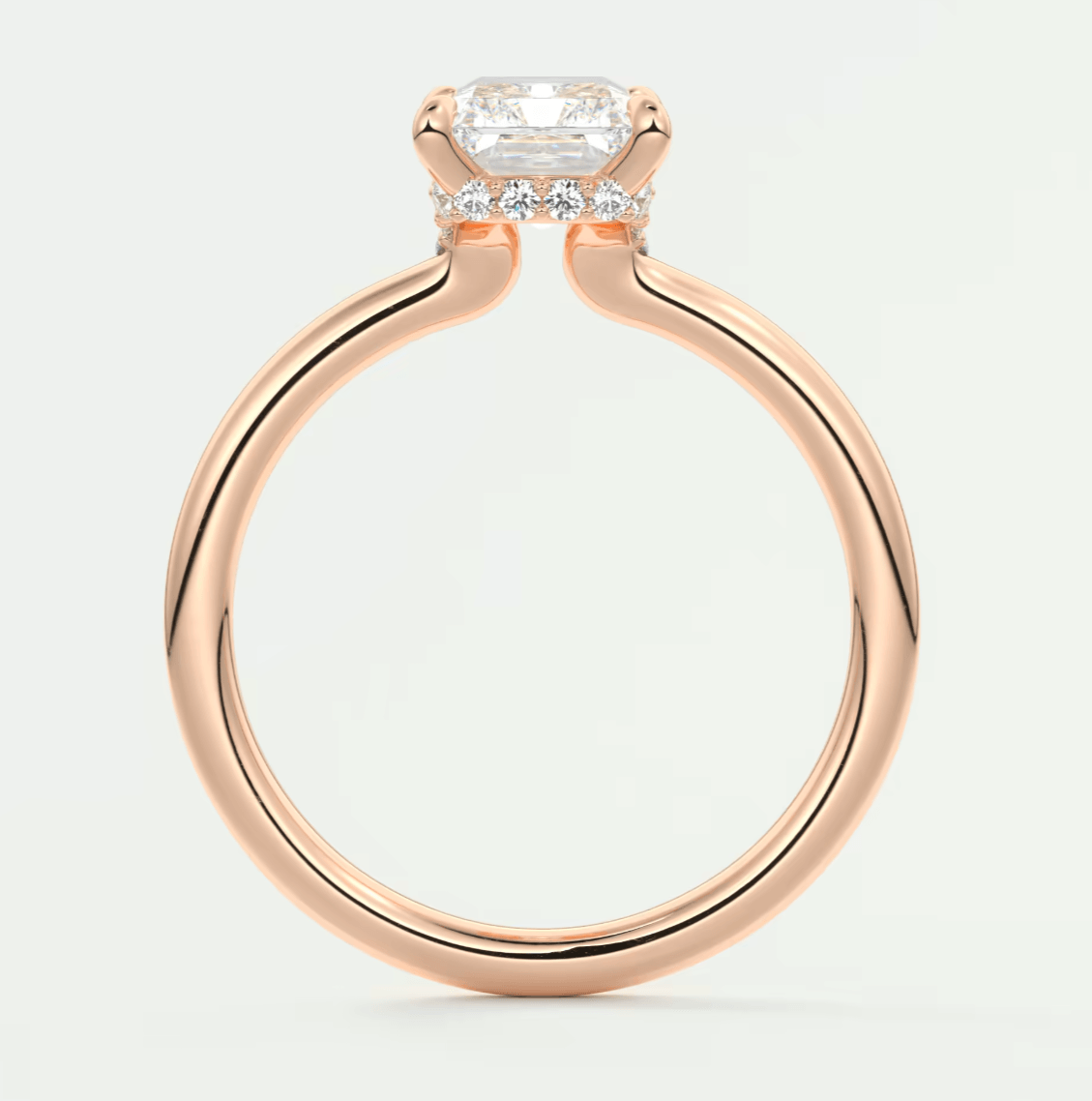Rose gold engagement ring with emerald cut diamond and side diamonds, featuring a sleek modern design.