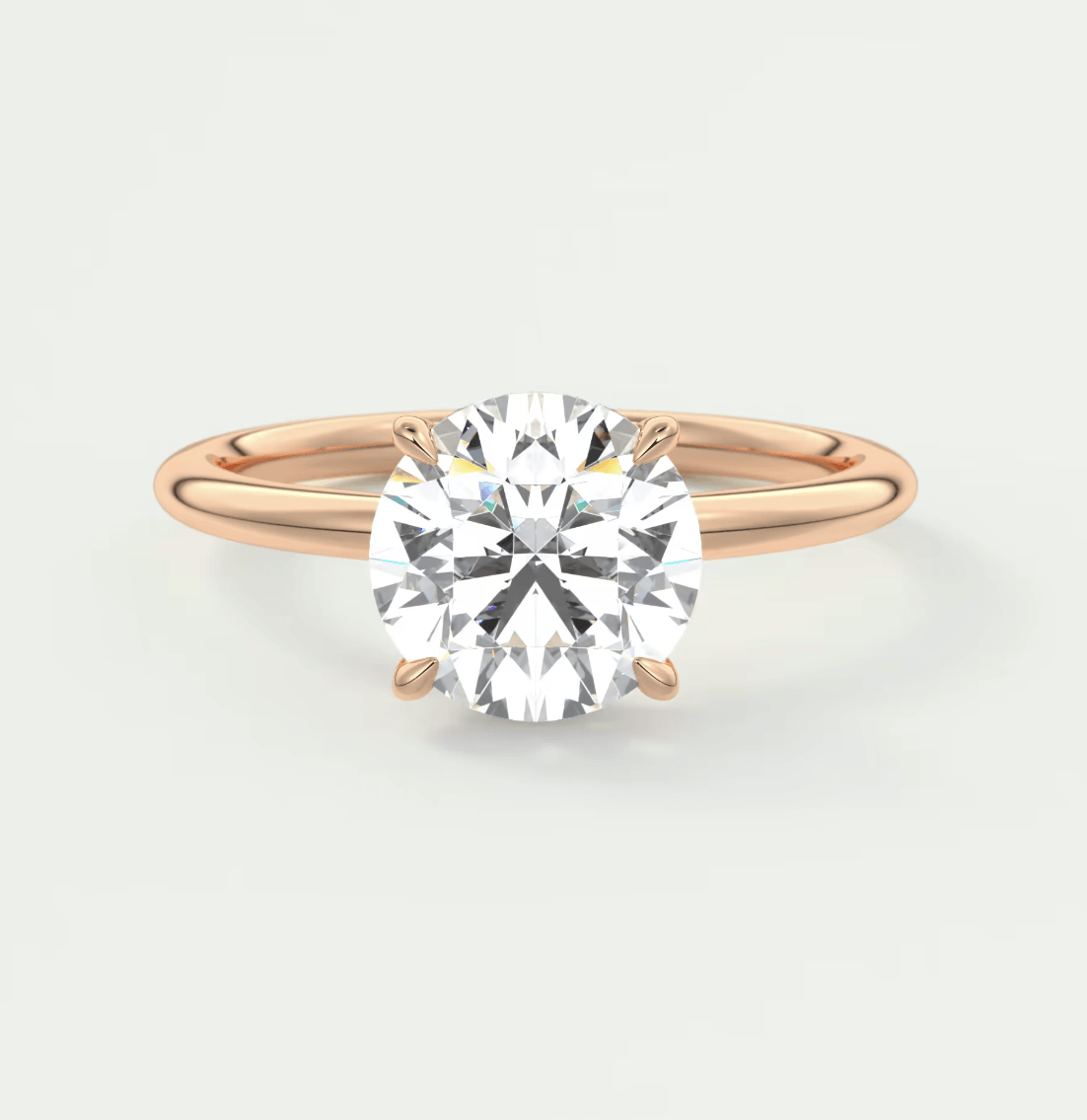 18-karat rose gold engagement ring with a round-cut diamond.