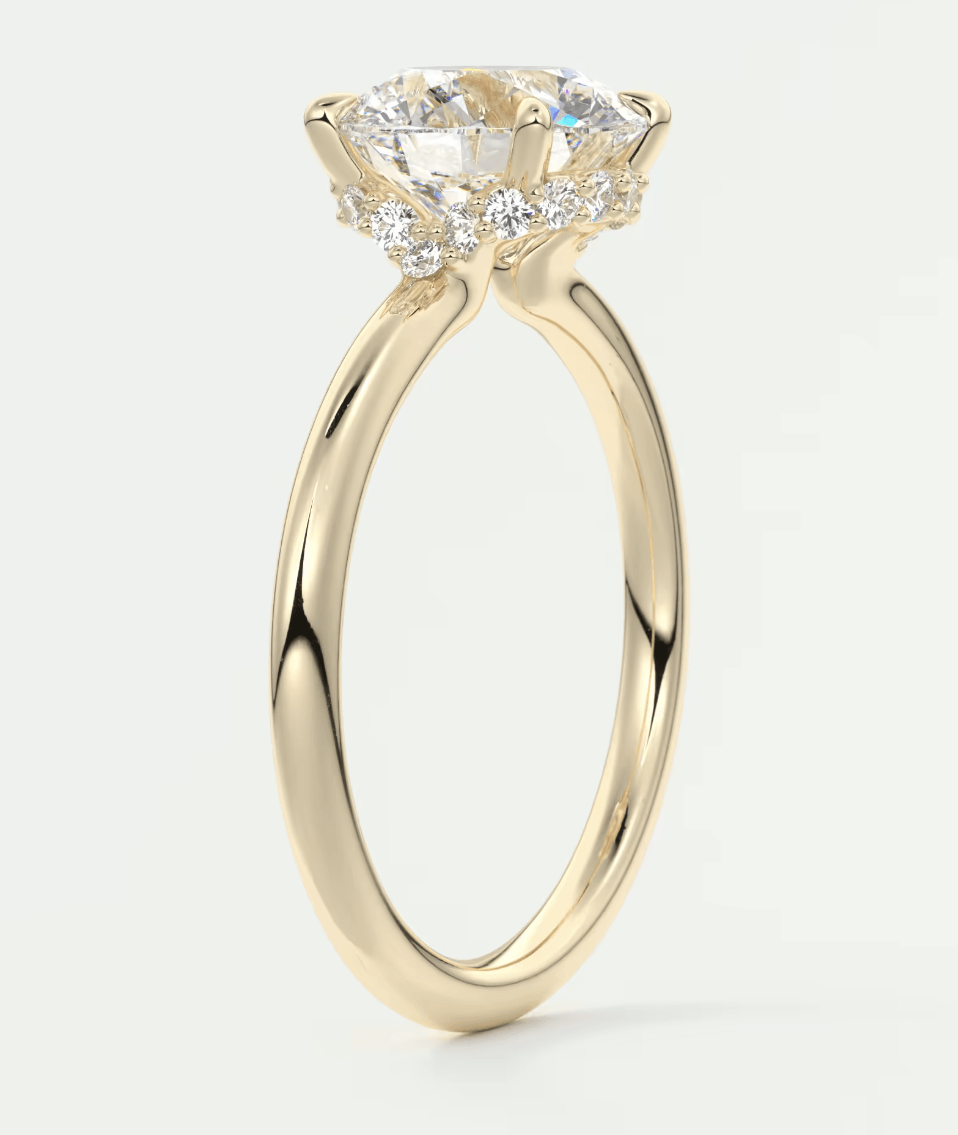 18-karat yellow gold engagement ring with a round diamond center stone and two smaller diamonds on either side.