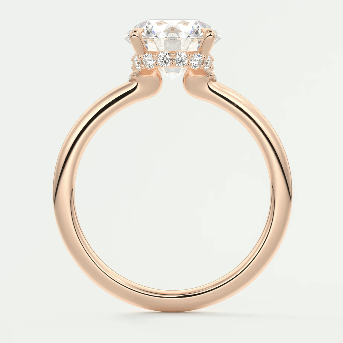 18-karat rose gold engagement ring with a cushion-cut diamond center stone and small diamonds on the band.