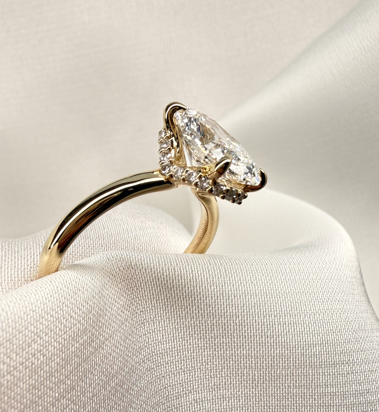 Gold ring with a large diamond on a soft white background