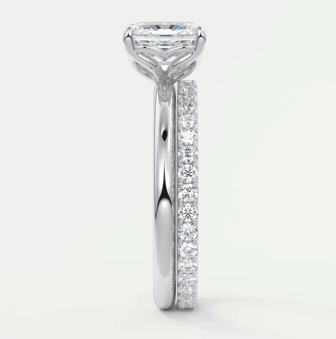 18k white gold engagement ring with a princess cut diamond and pavé set diamonds on the band.