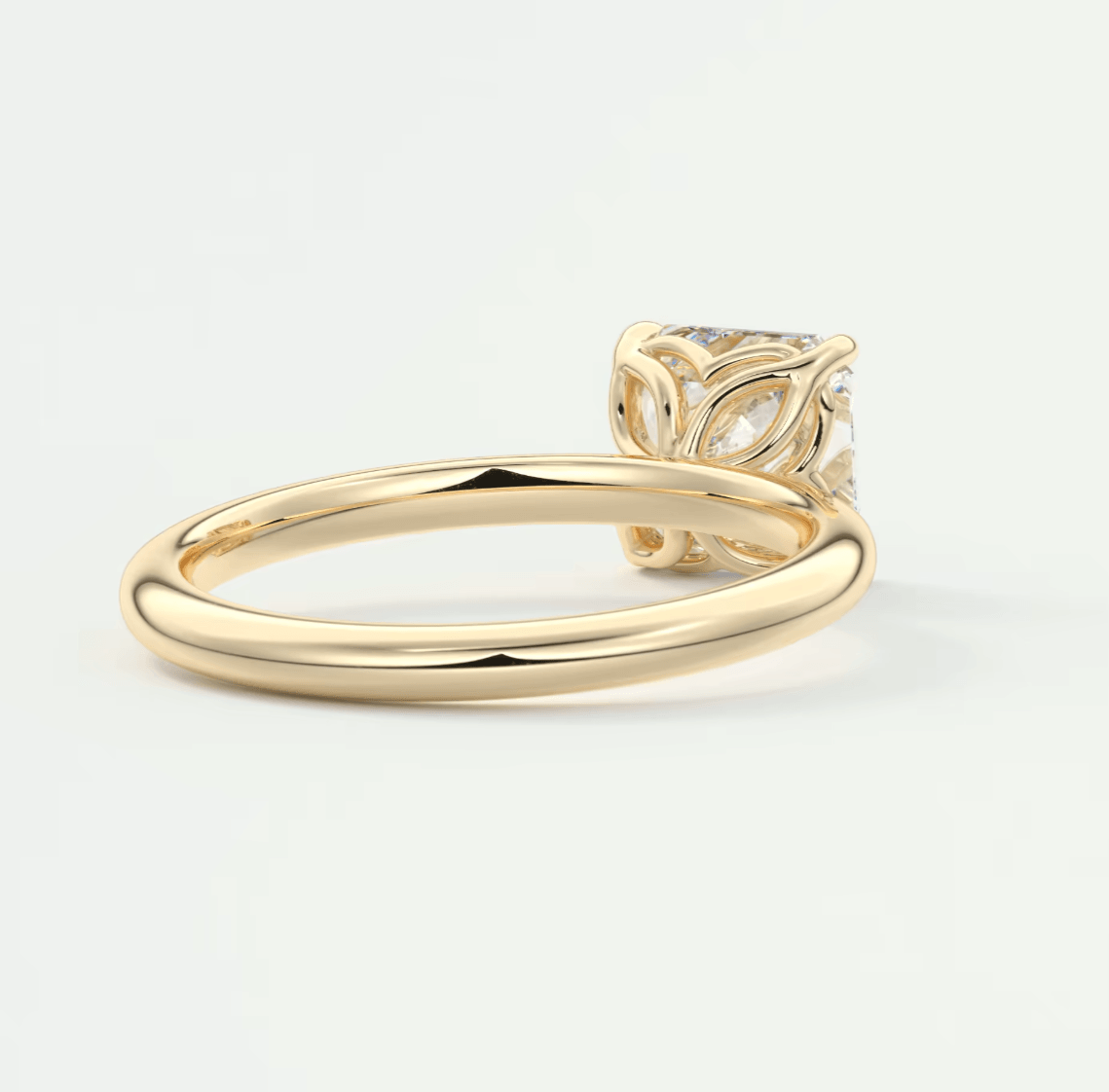 18k gold engagement ring with a diamond center stone and floral engraving.