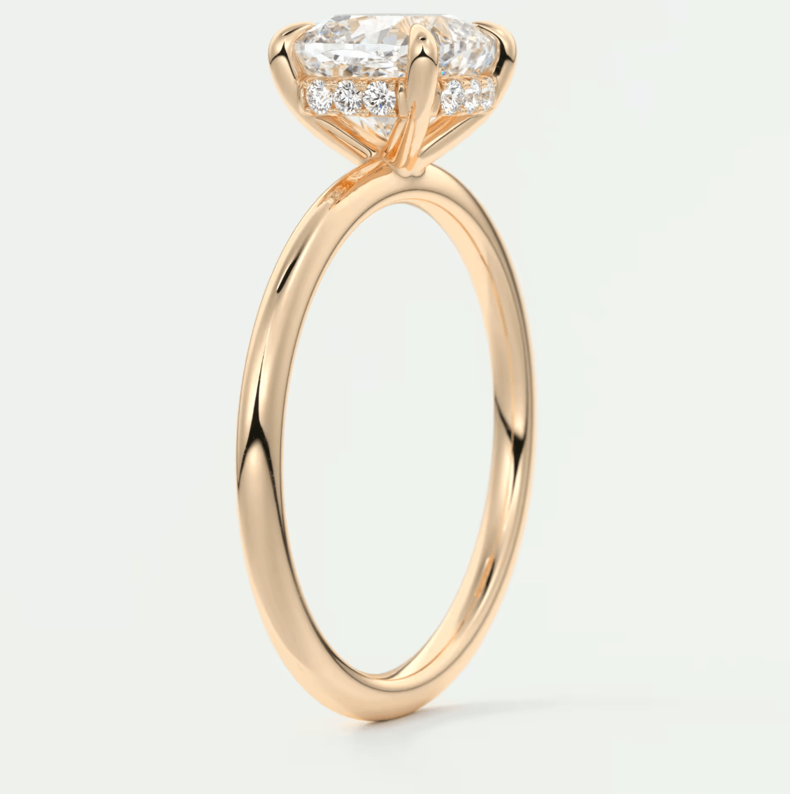 18k rose gold engagement ring with a princess cut diamond and smaller diamonds set in the band.