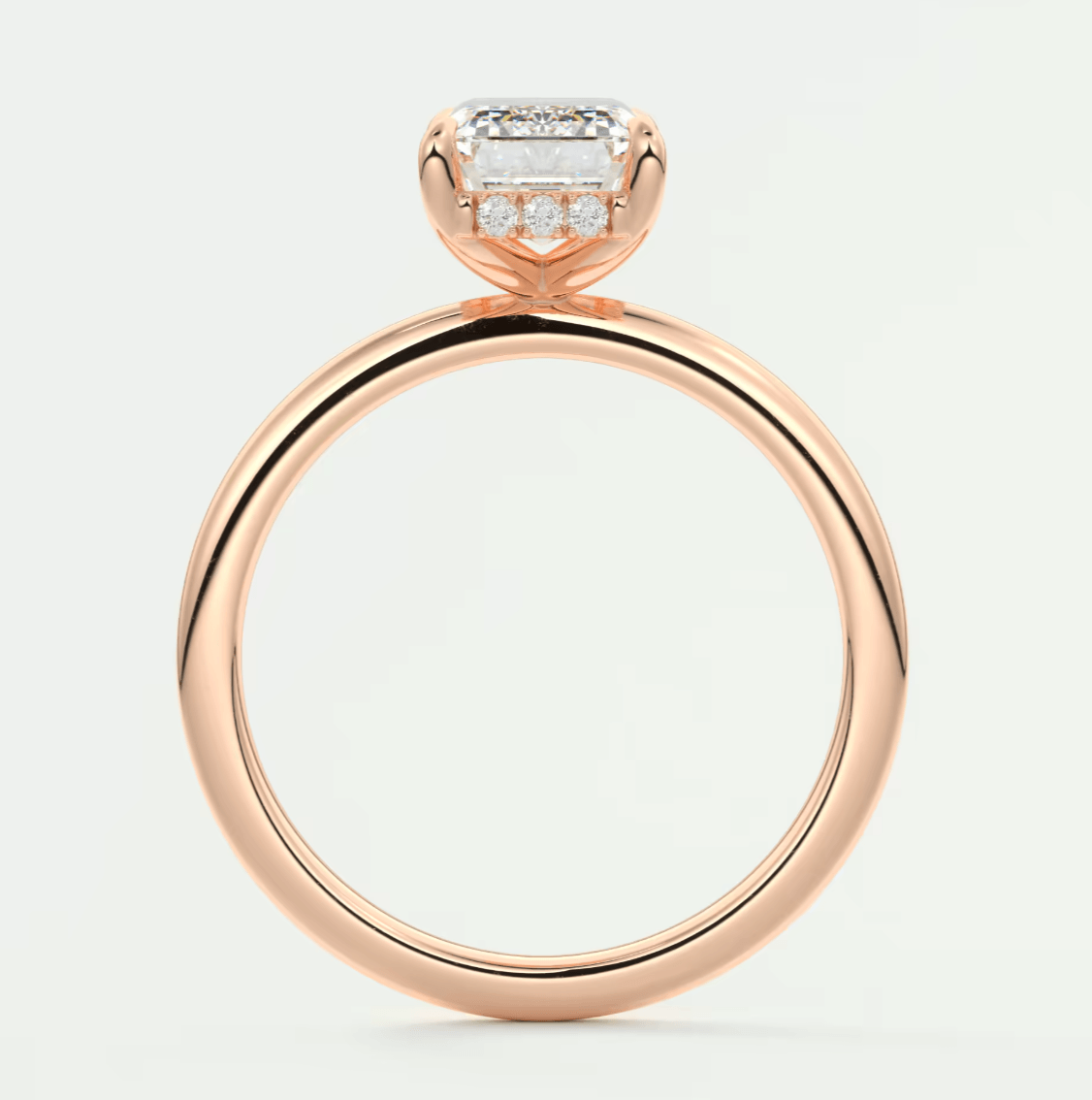 Rose gold diamond engagement ring with a square-cut center stone and smaller diamonds set in the band.