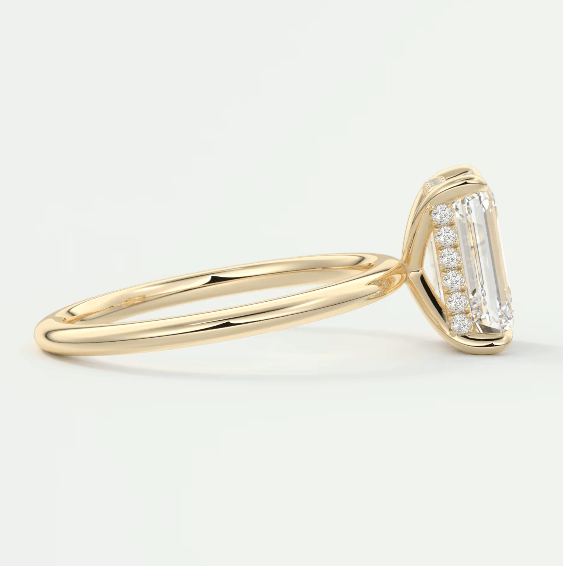 18k yellow gold diamond engagement ring with emerald-cut center stone and baguette side stones.
