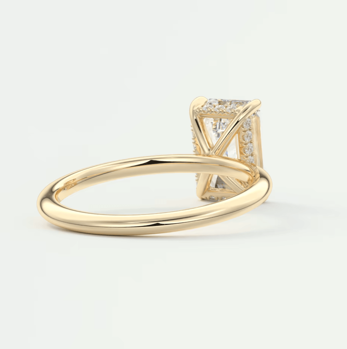 18k yellow gold diamond engagement ring with a princess cut center stone and pave set side stones.
