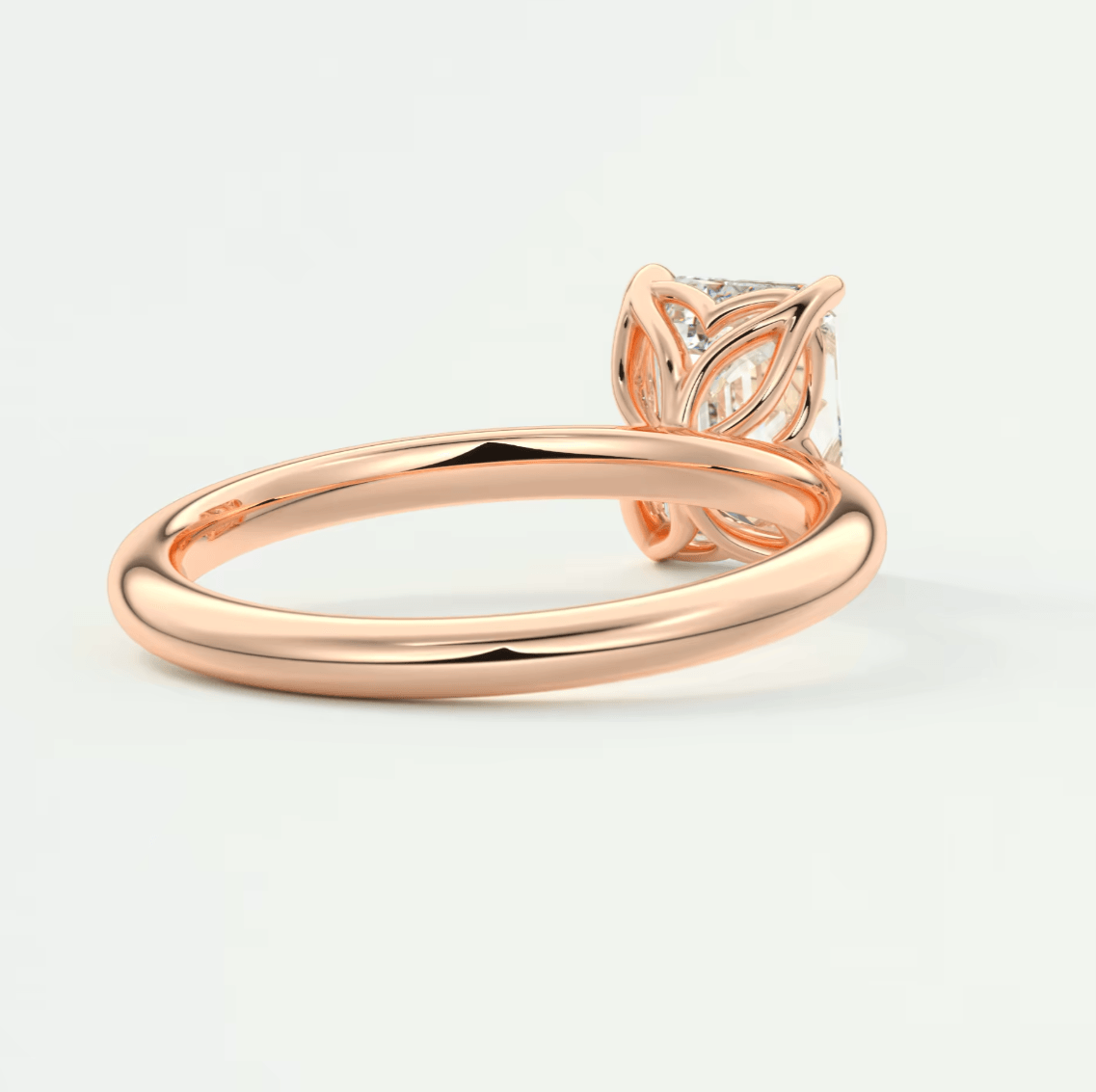 Rose gold engagement ring with a leaf-inspired design and diamond center stone.
