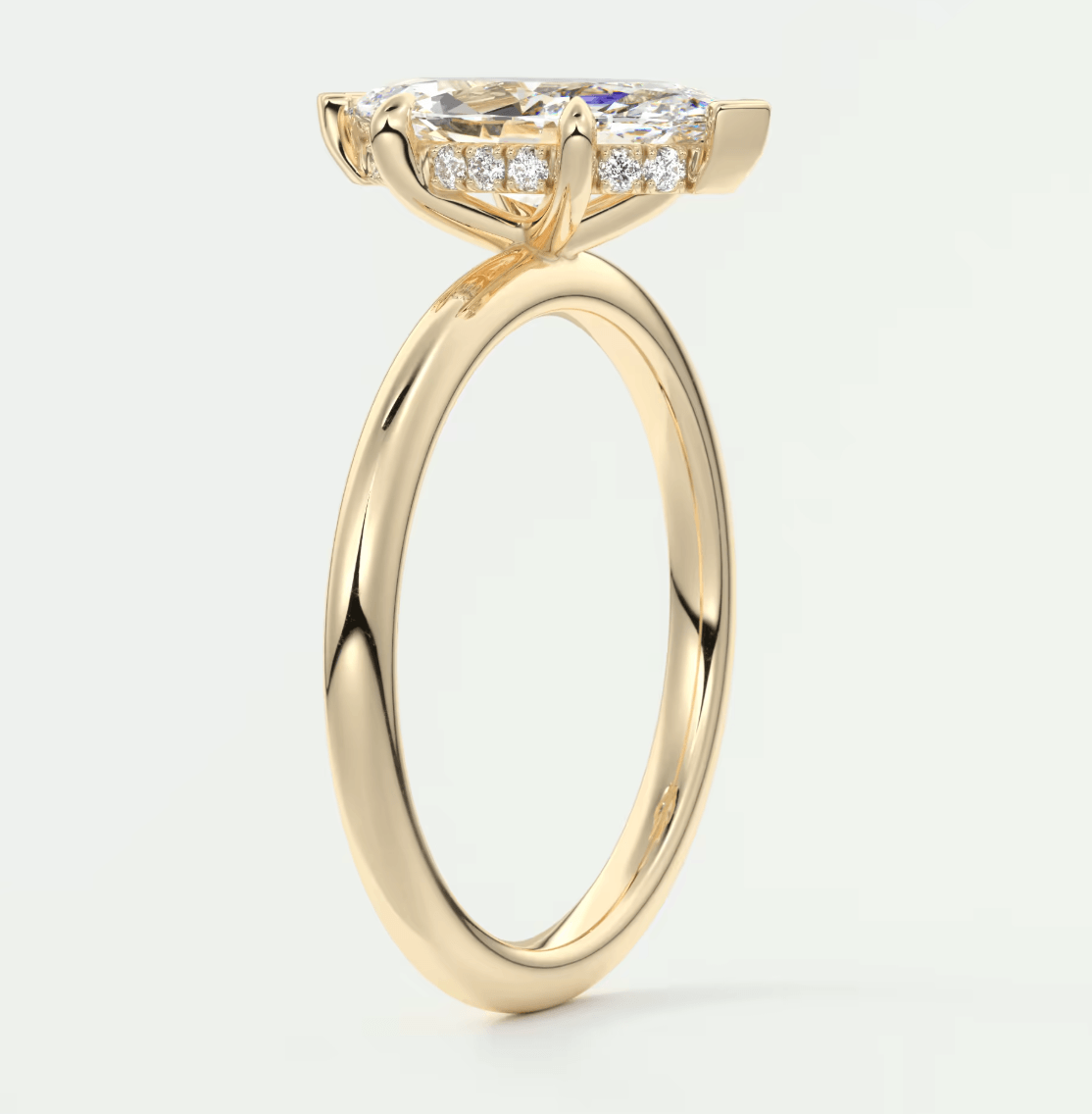 18-karat yellow gold engagement ring with a cushion-cut diamond and smaller diamonds set in the band.