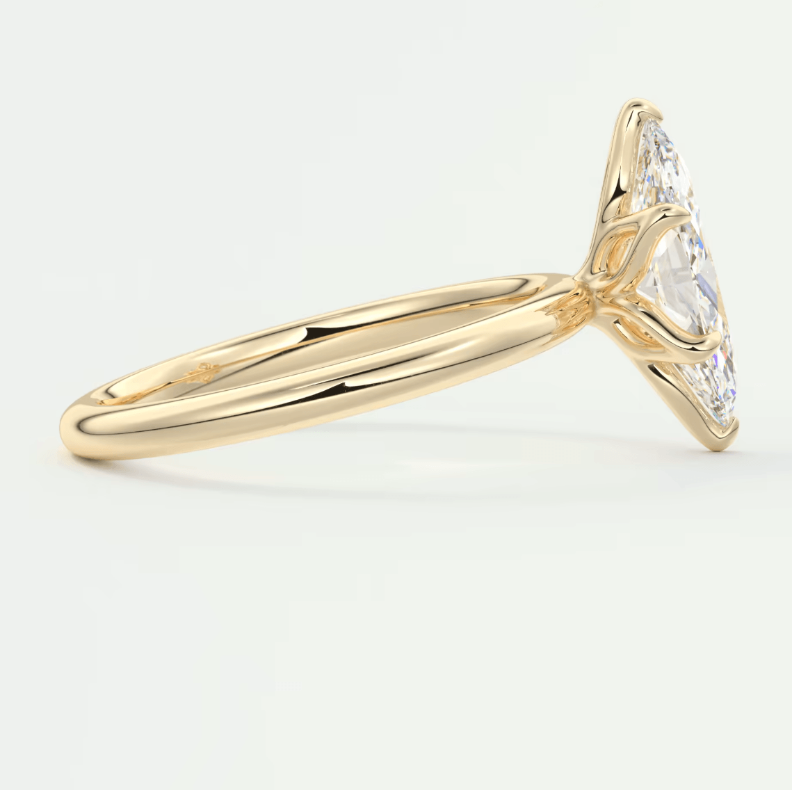 18k yellow gold diamond engagement ring with a marquise-cut center stone and small diamonds on the band.