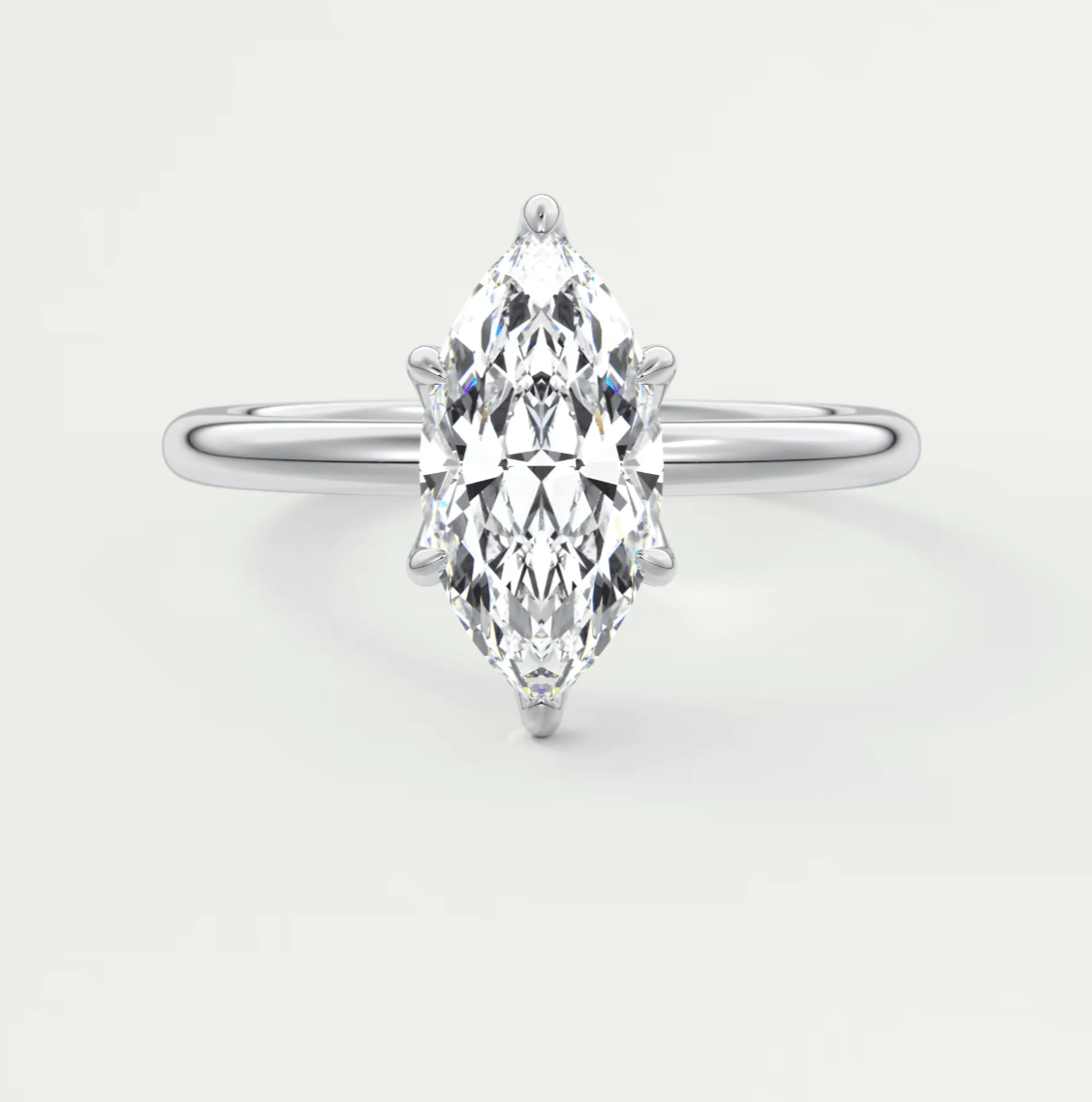 Marquise-cut diamond engagement ring with white gold band, featuring a central stone and intricate prong setting.