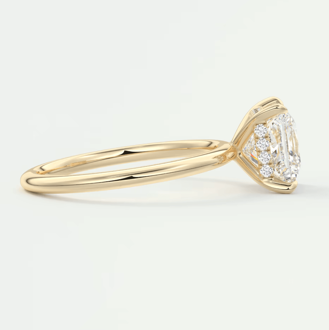 18k yellow gold emerald cut diamond engagement ring with halo detailing.