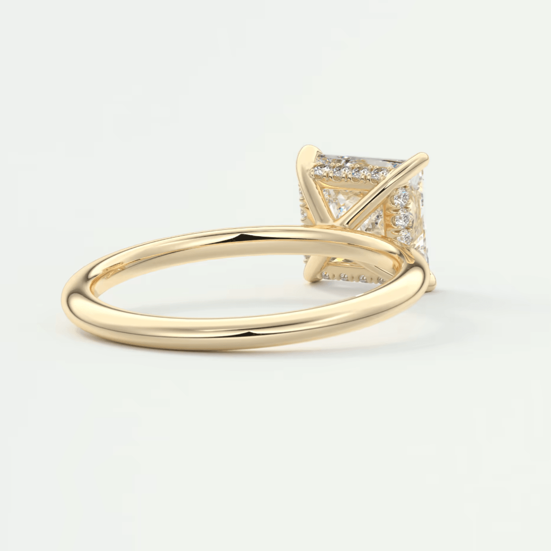 18k yellow gold princess cut diamond engagement ring with a halo of smaller diamonds.