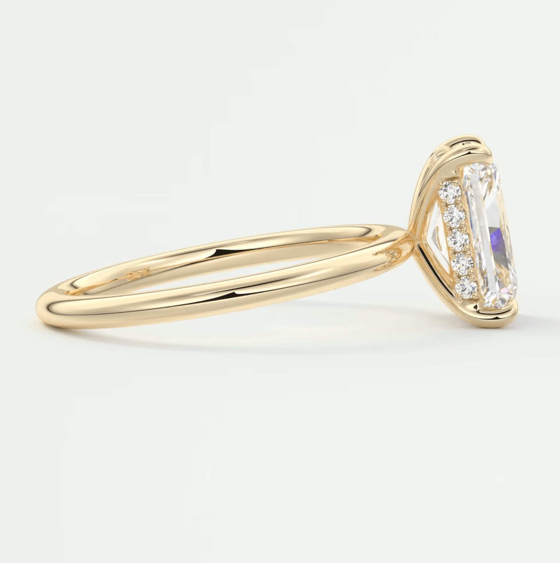 18k yellow gold engagement ring with emerald-cut diamond and small round diamonds set in a halo design.