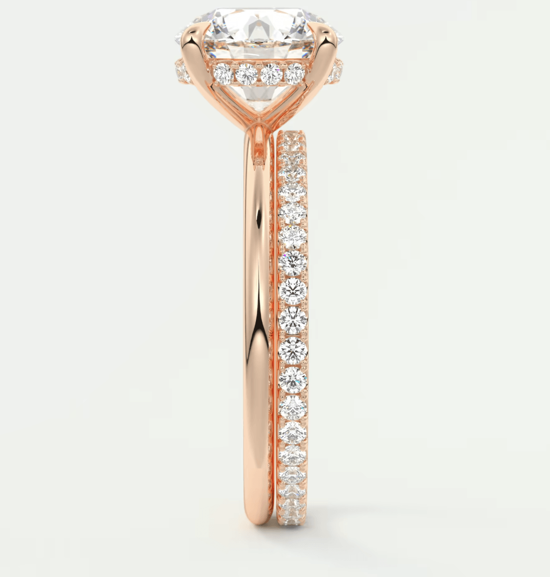 18-karat rose gold engagement ring with a cushion-cut diamond and pavé side stones.