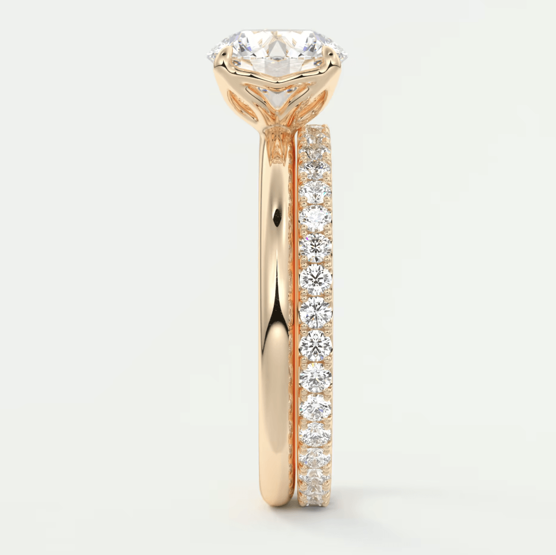 18k rose gold diamond engagement ring with a round brilliant cut center stone and pavé set diamonds on the band.
