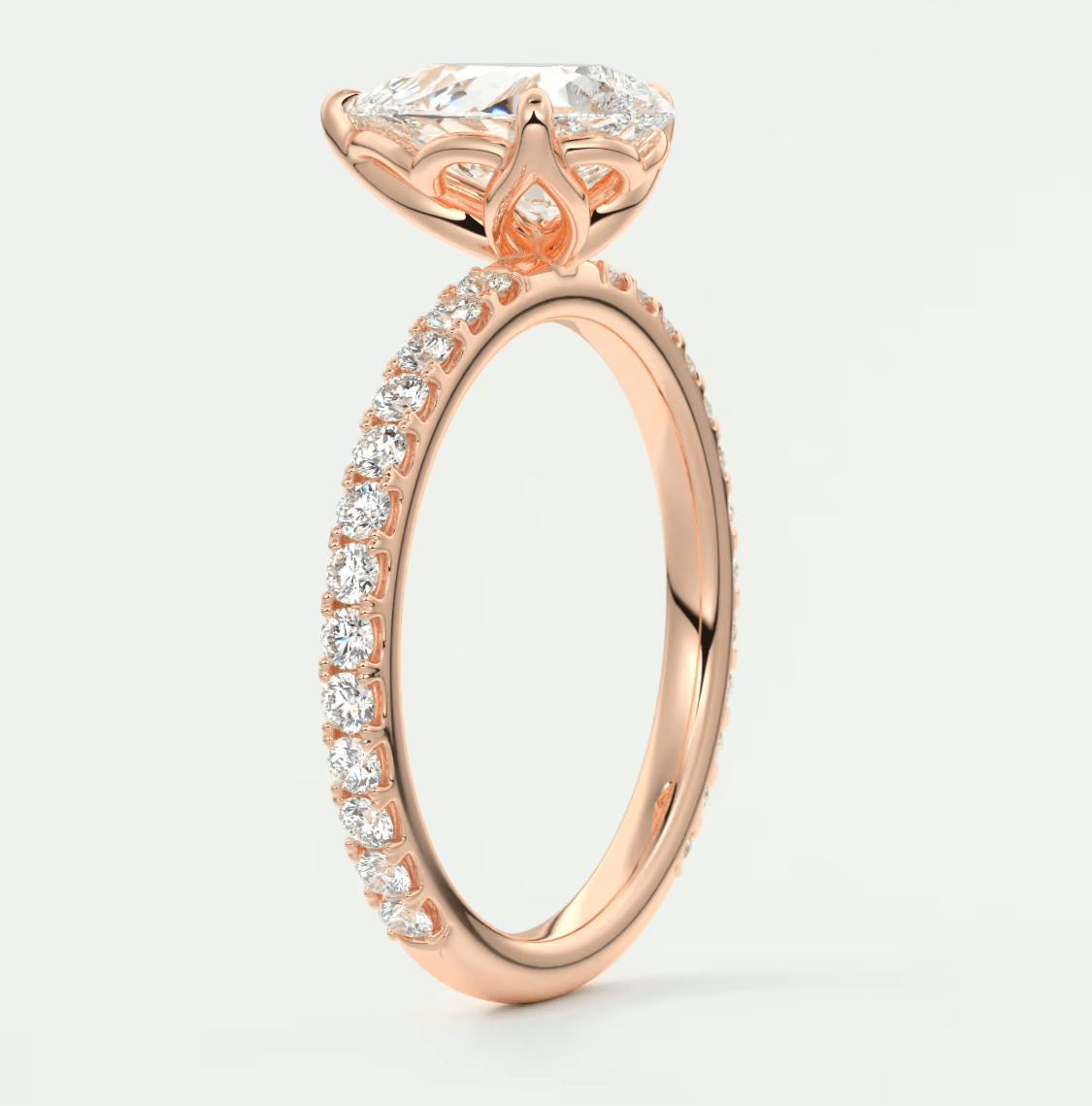 Rose gold engagement ring with a large central diamond and smaller diamonds along the band, featuring an intricate floral design.