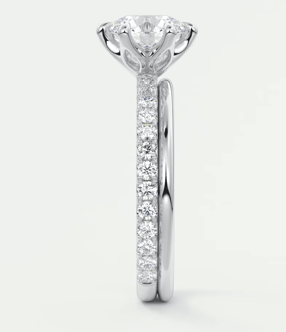 18k white gold diamond engagement ring with a round brilliant cut center stone and pavé set diamonds on the band.