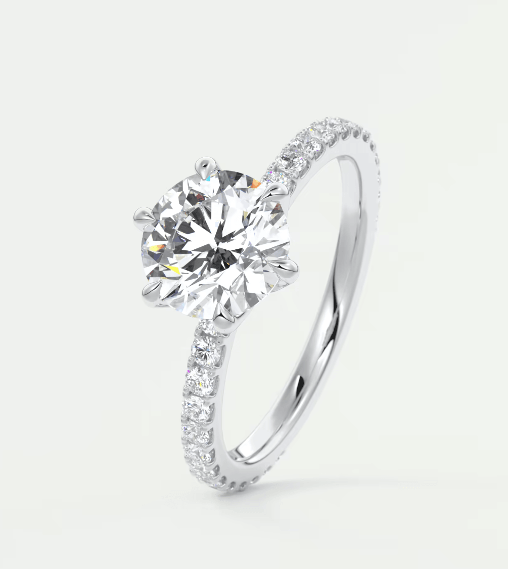 18k white gold diamond engagement ring with a round-cut center stone and pave-set diamonds on the band.