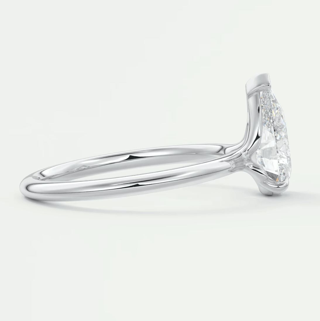 18-karat white gold diamond engagement ring with a marquise-cut center stone and pave-set side diamonds.