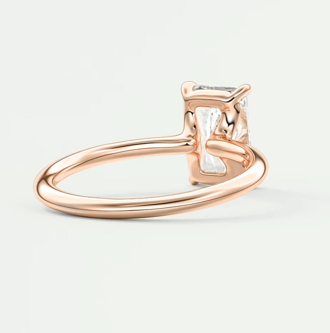 Rose gold diamond engagement ring with a square-cut gemstone and four-prong setting.