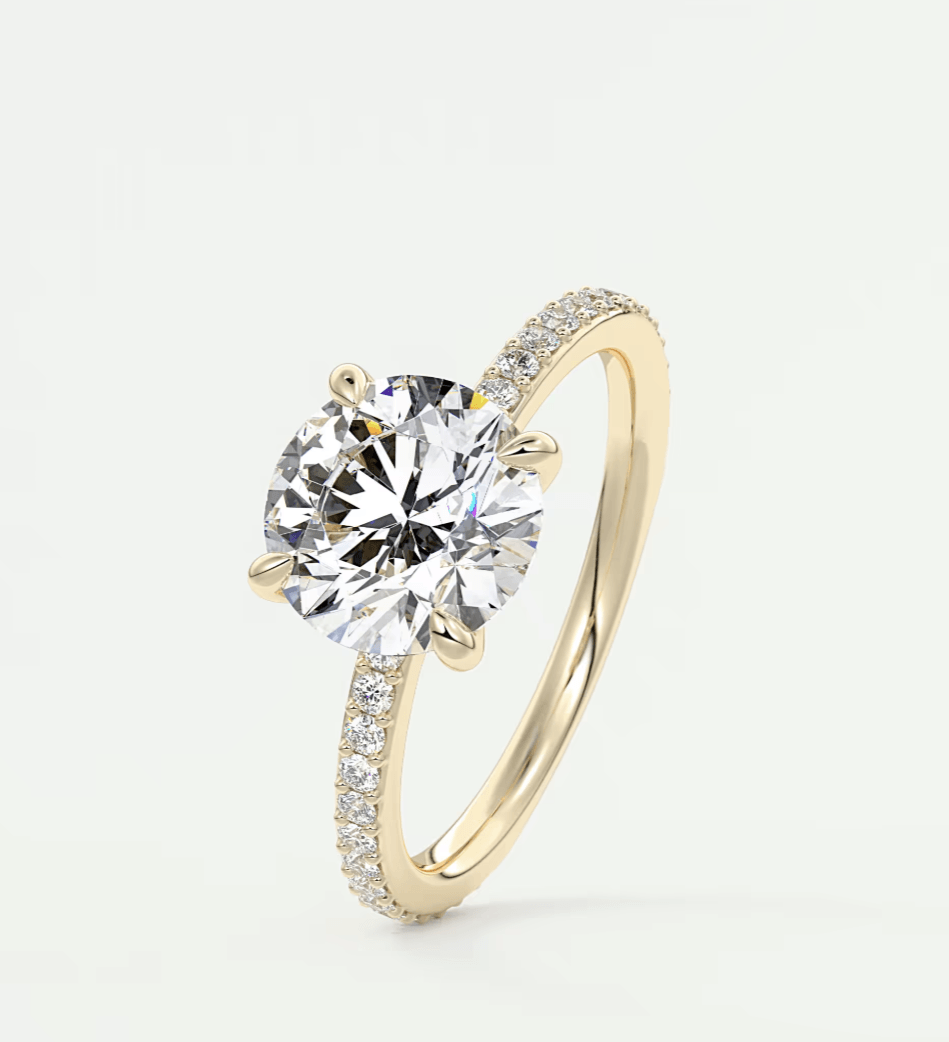 18k yellow gold engagement ring with a round diamond center stone and pave set diamonds on the band.