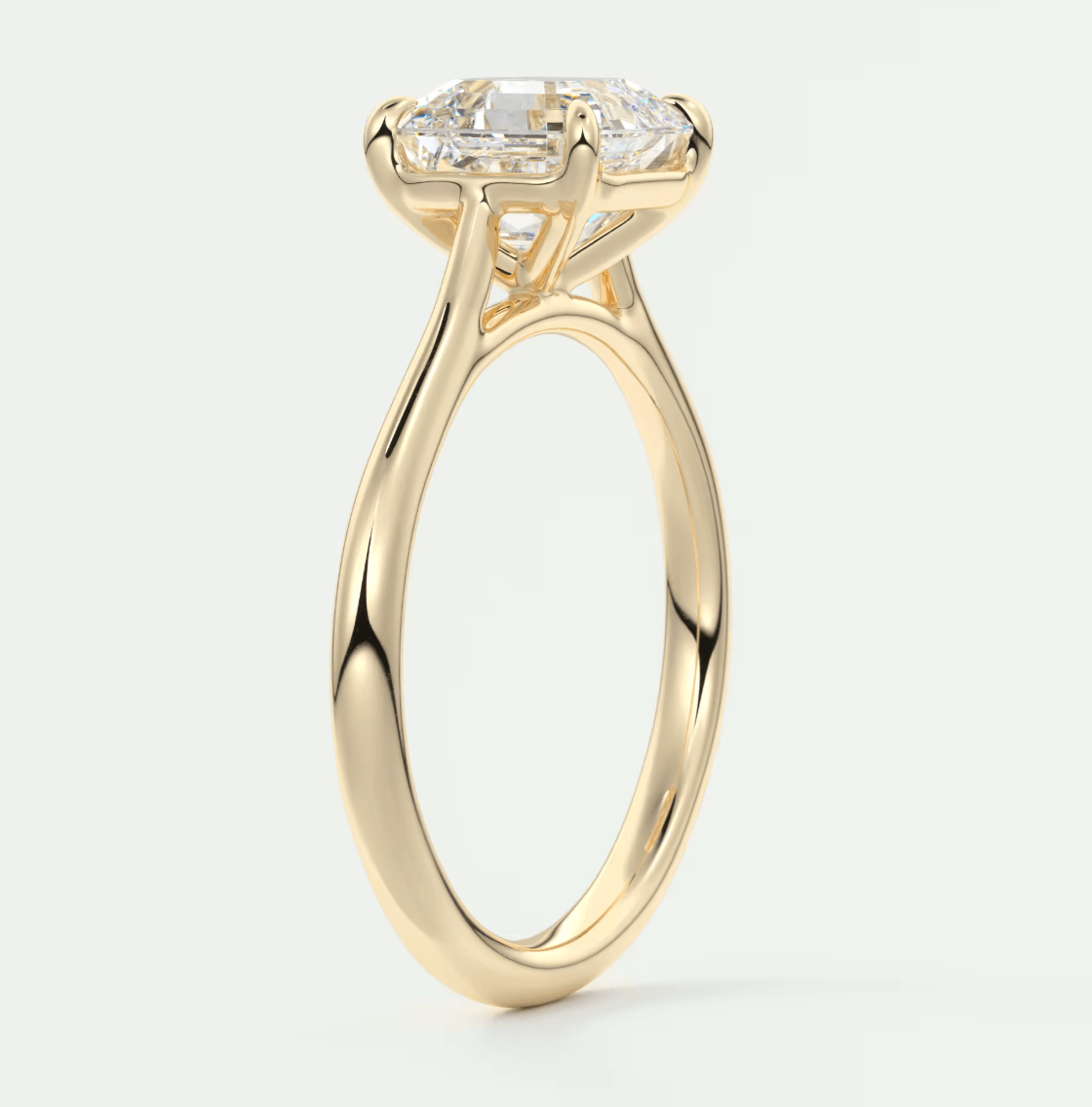 18k yellow gold engagement ring with a marquise-cut diamond and two smaller diamonds on the band.