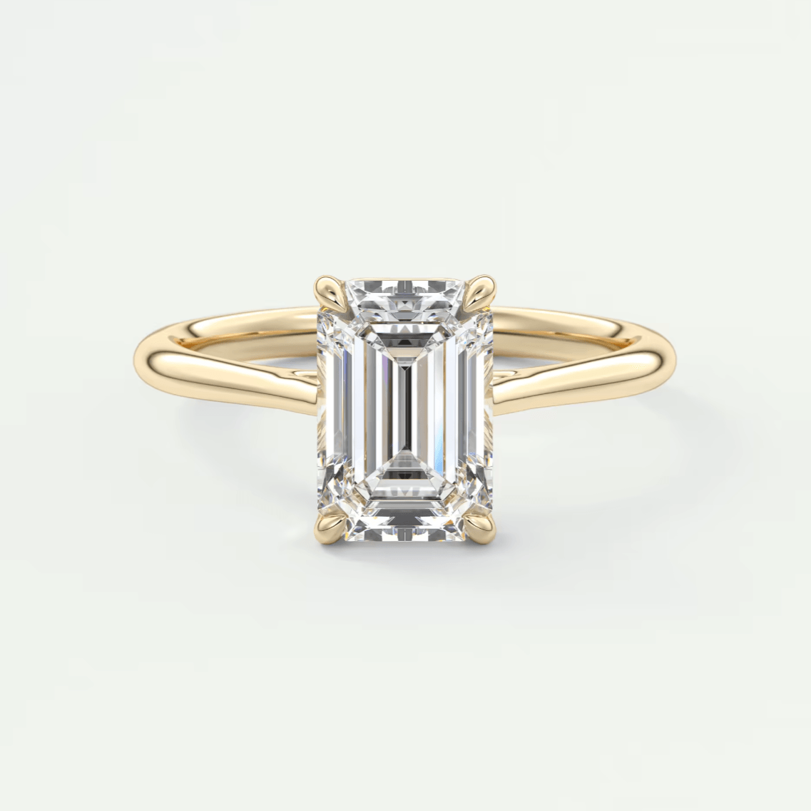 18k yellow gold emerald cut diamond engagement ring with a solitaire design.