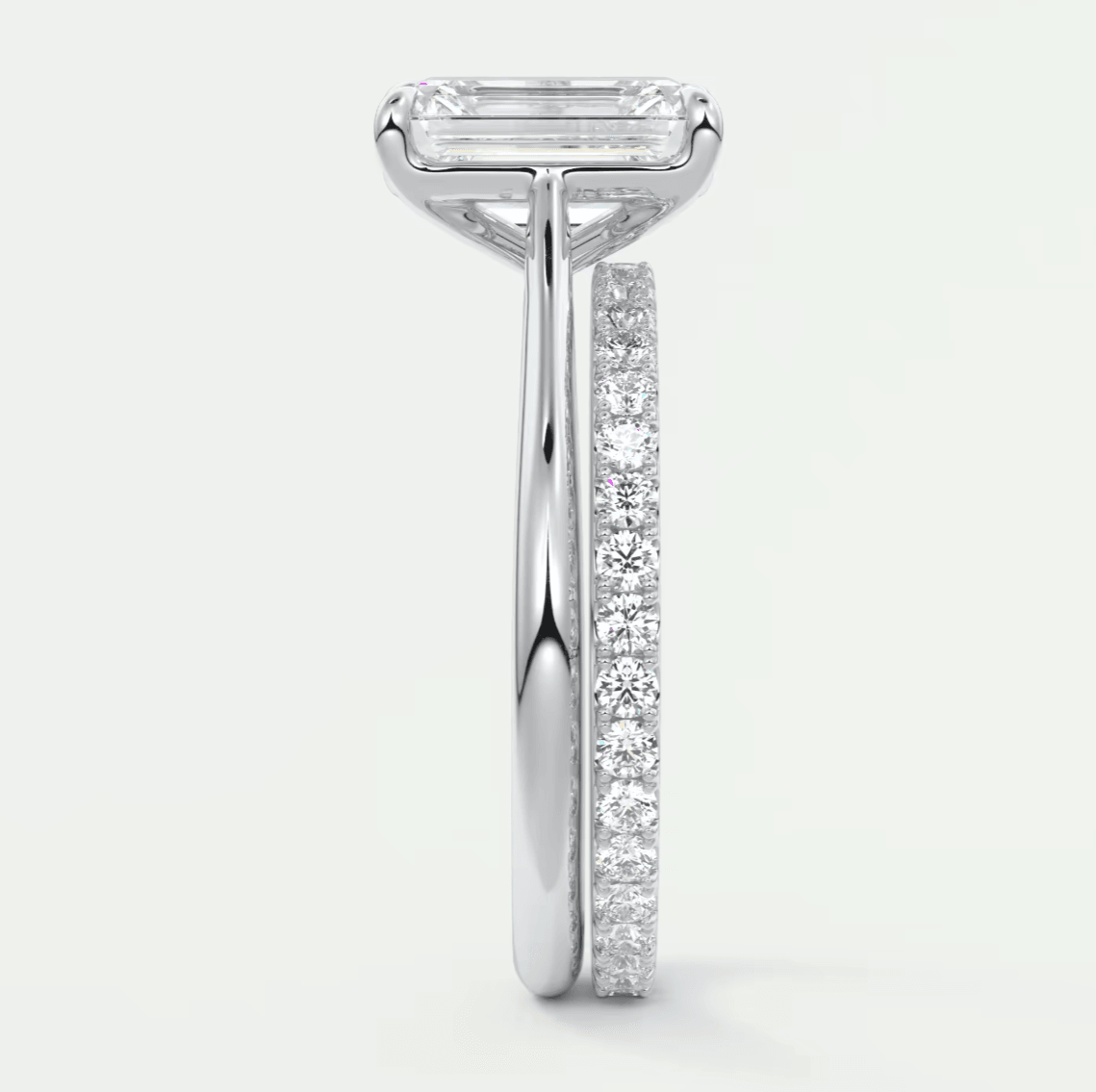 18k white gold engagement ring with an emerald-cut diamond and a pave-set band.