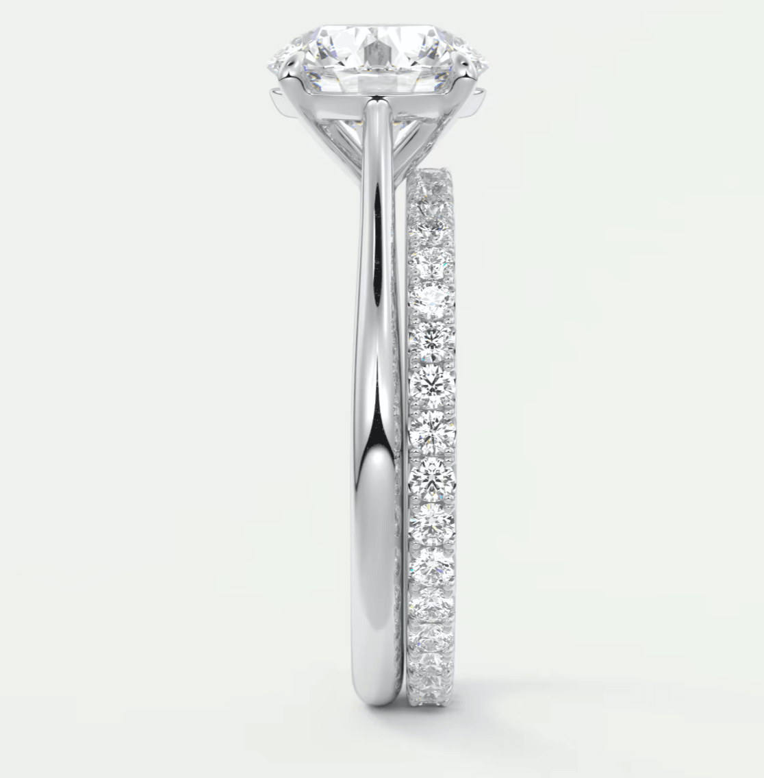 18-karat white gold diamond engagement ring with a round brilliant cut center stone and channel set diamonds on the band.