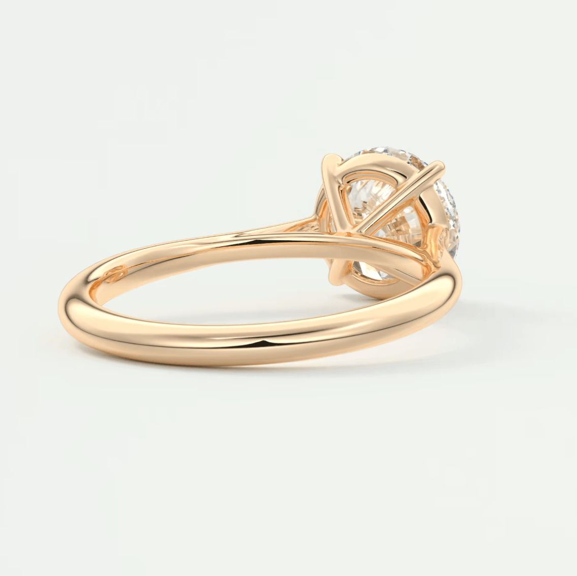 18k yellow gold engagement ring with a round diamond center stone and intricate leaf design.