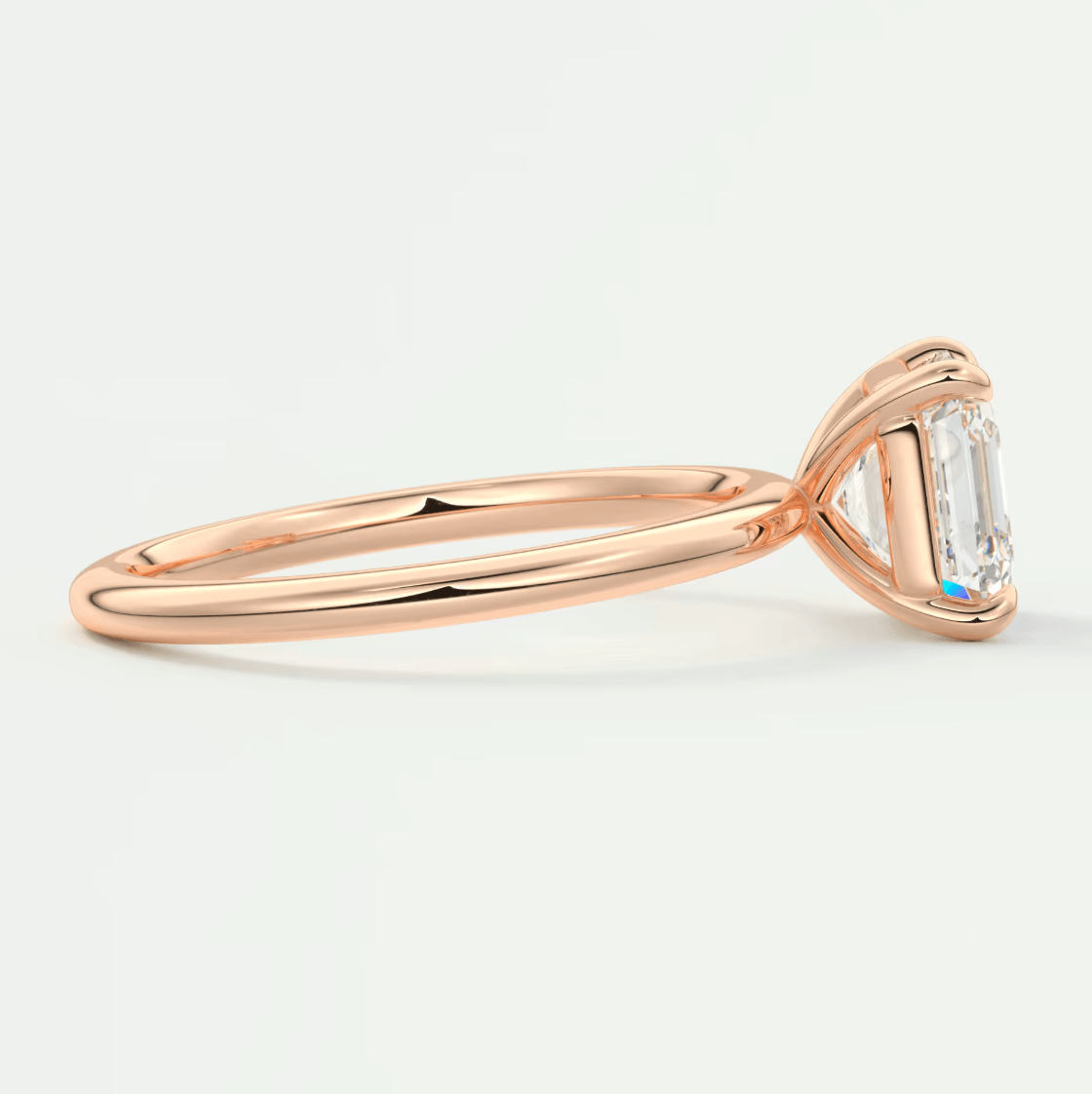 18-karat rose gold engagement ring with an emerald-cut diamond.