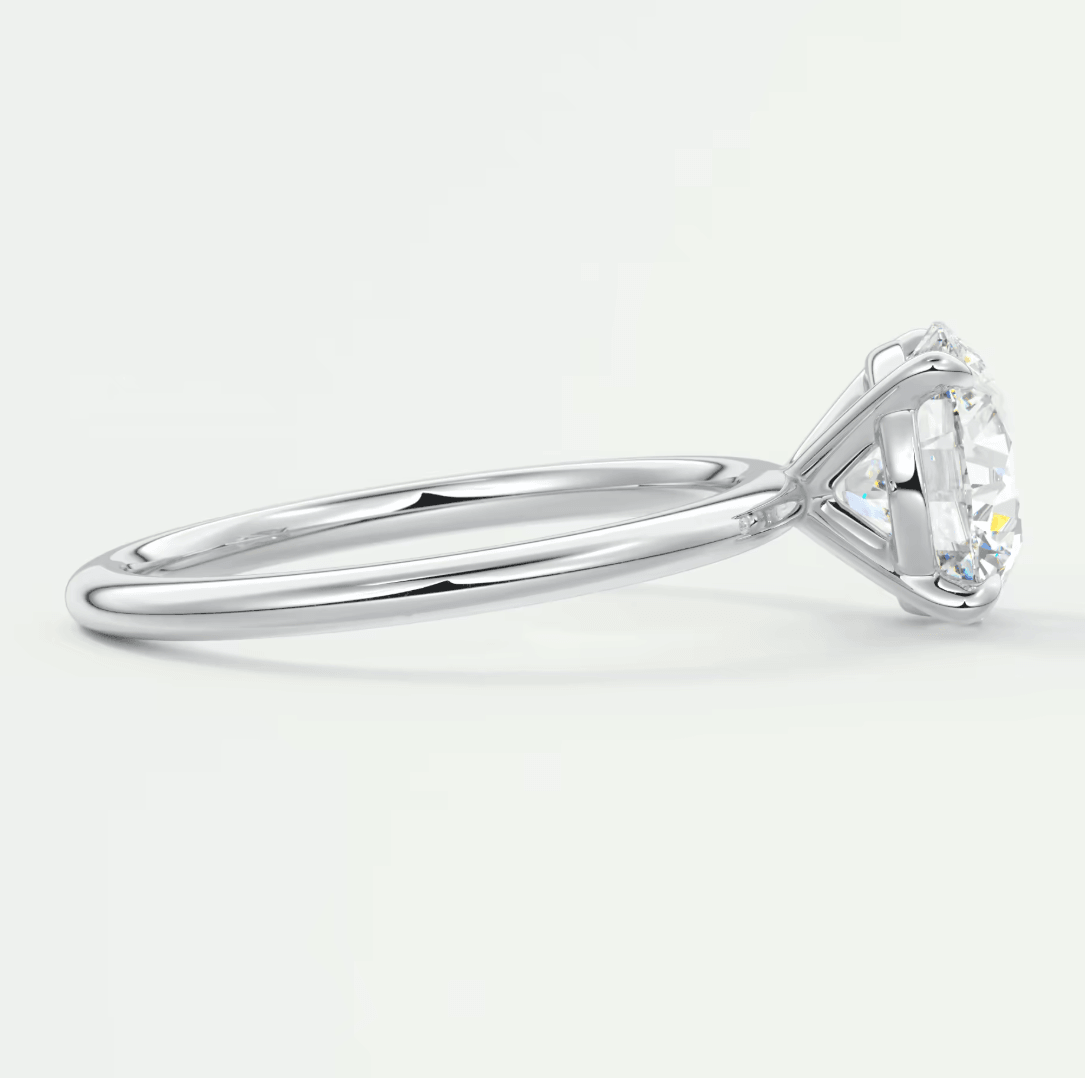18k white gold diamond engagement ring with a round-cut center stone and small side diamonds.