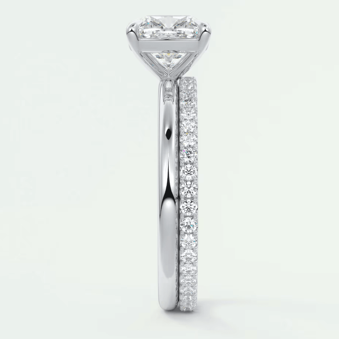 18k white gold diamond engagement ring with a princess cut center stone and pavé set diamonds on the band.