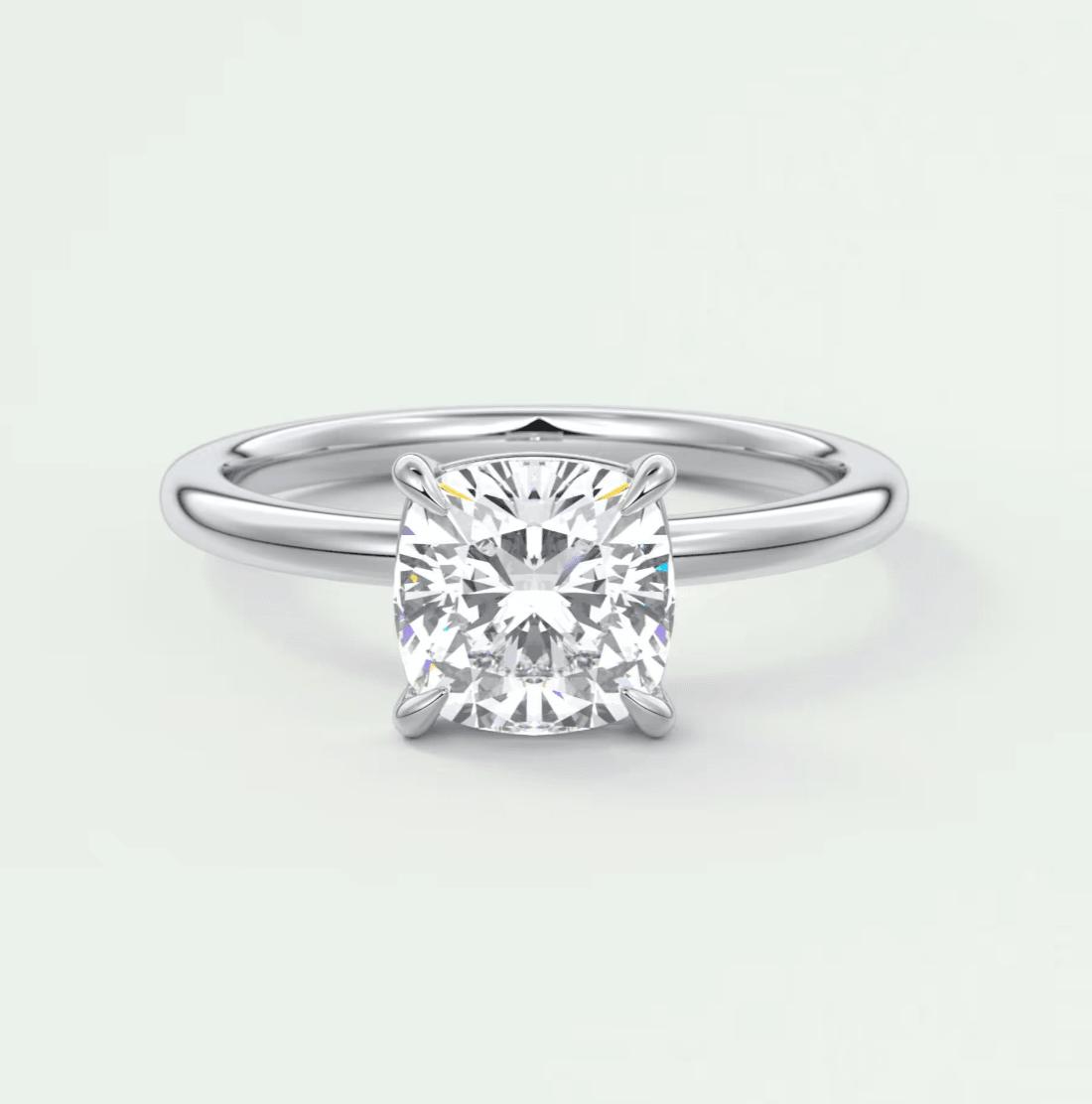 Cushion-cut diamond engagement ring with four prongs, platinum or white gold.