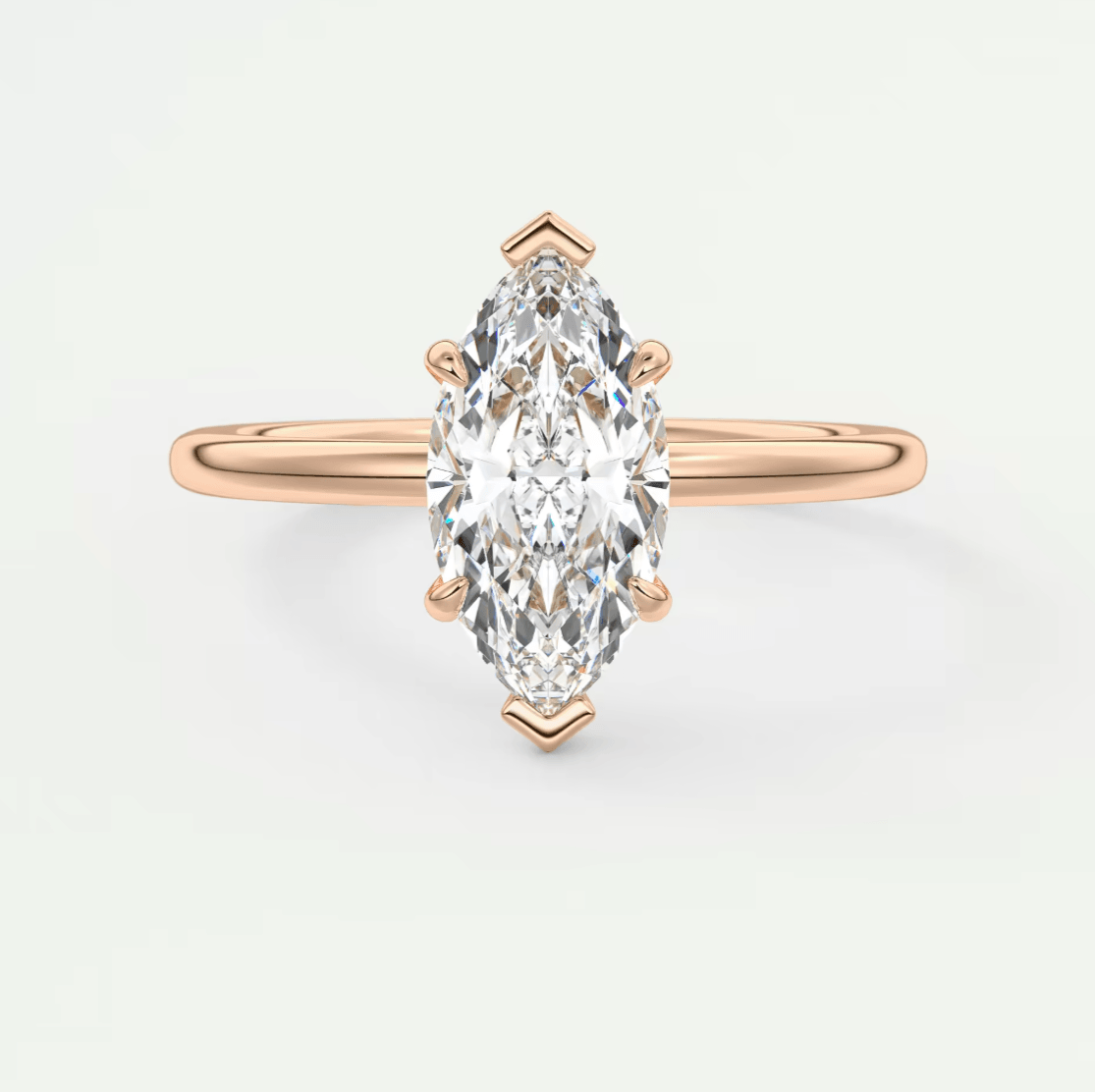 Rose gold marquise diamond engagement ring with three prongs and a sleek band design.