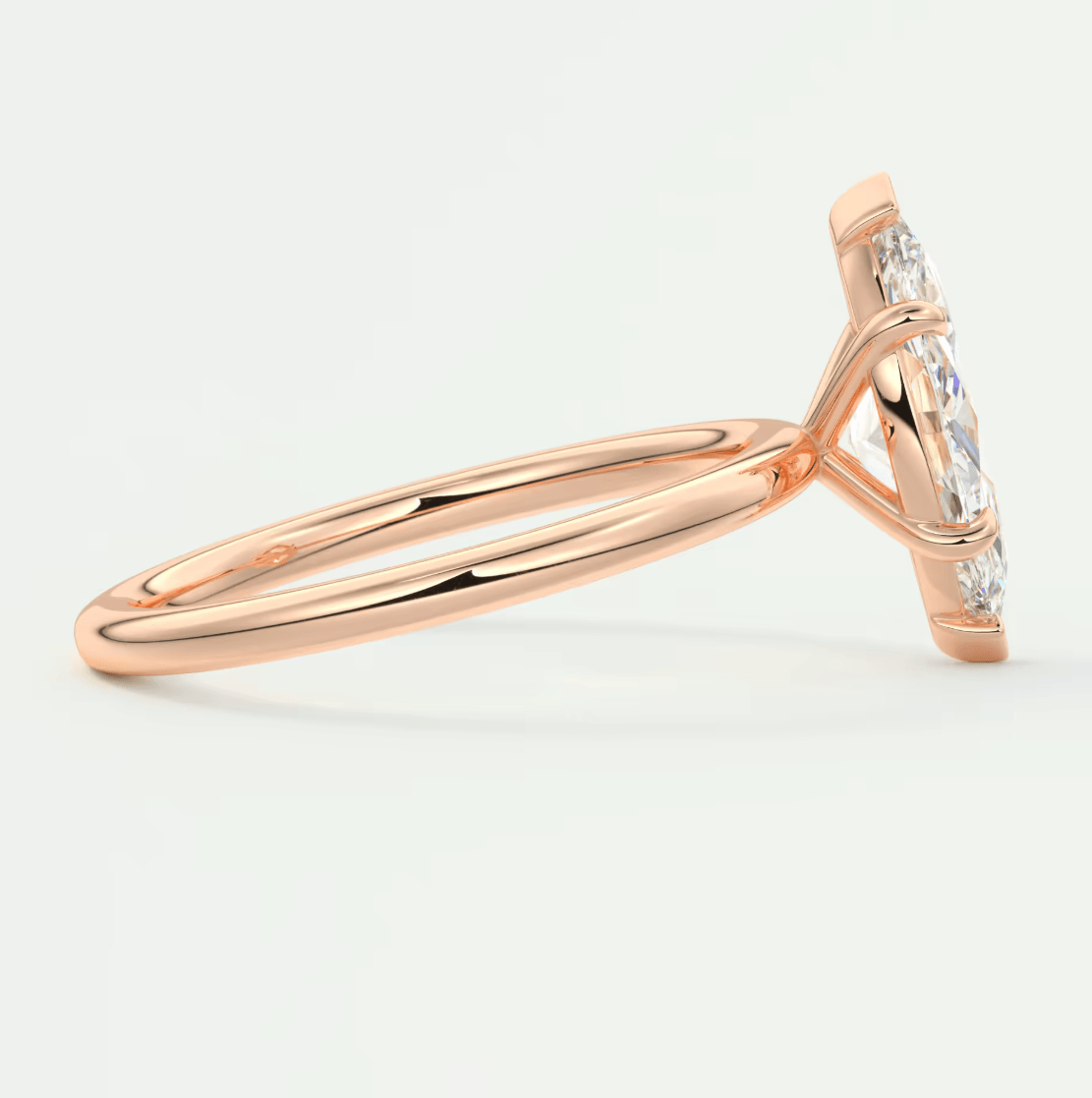 Rose gold diamond engagement ring with marquise cut gemstones and delicate band design.