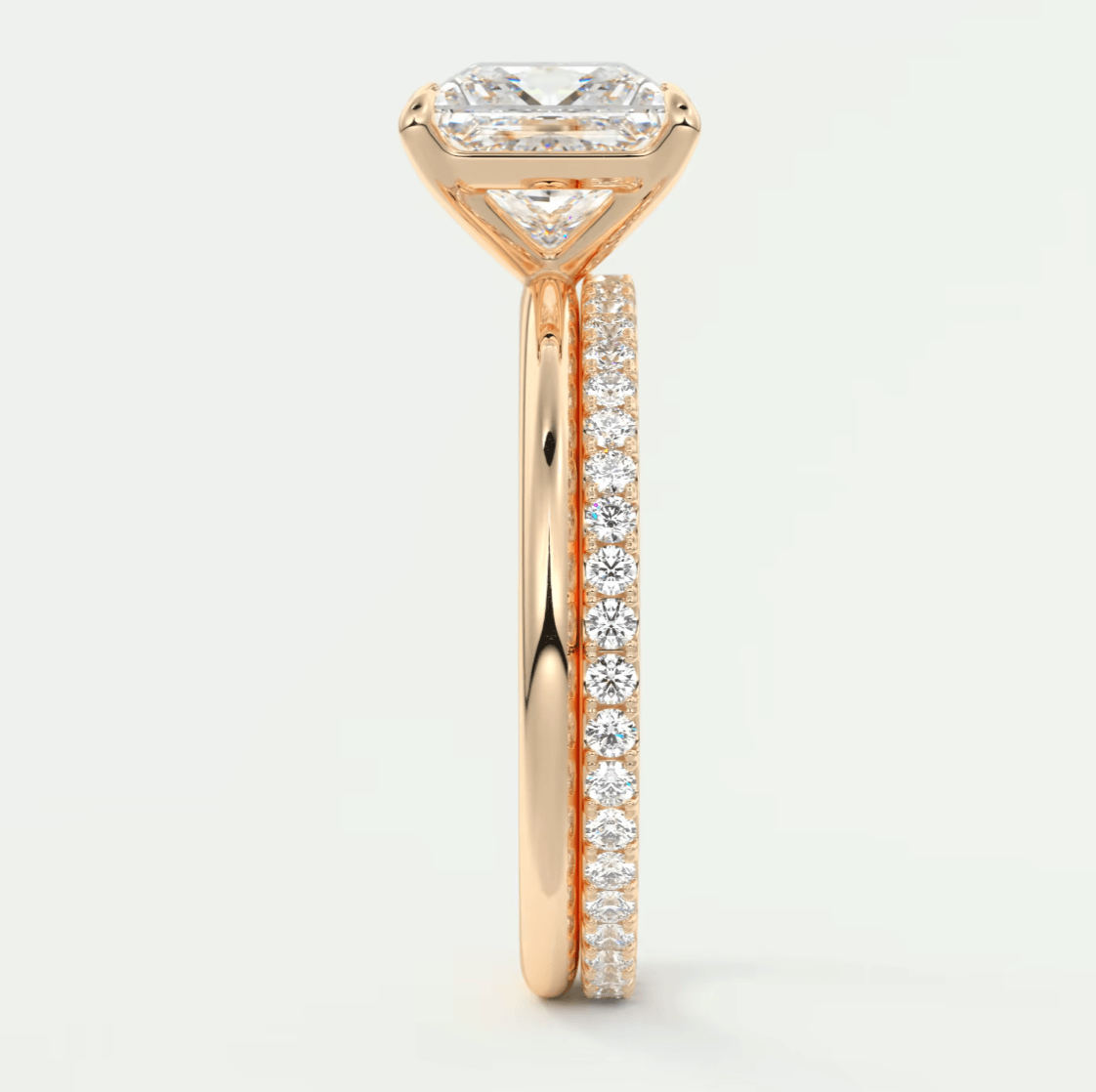 18k rose gold engagement ring with a princess cut diamond and pavé side stones.