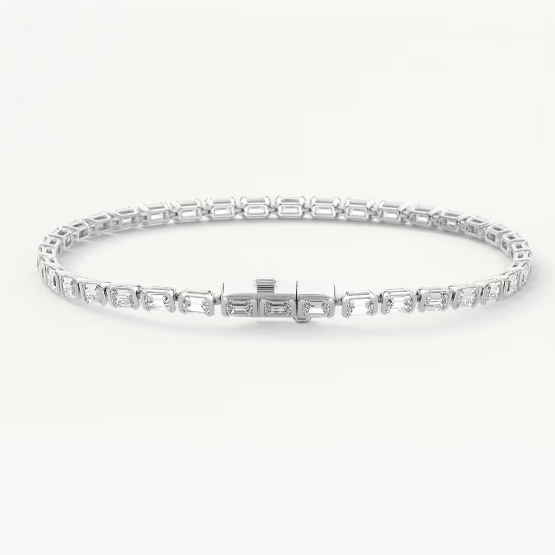 A silver tennis bracelet with rectangular baguette-cut stones, displayed in a circular shape against a clean white background.