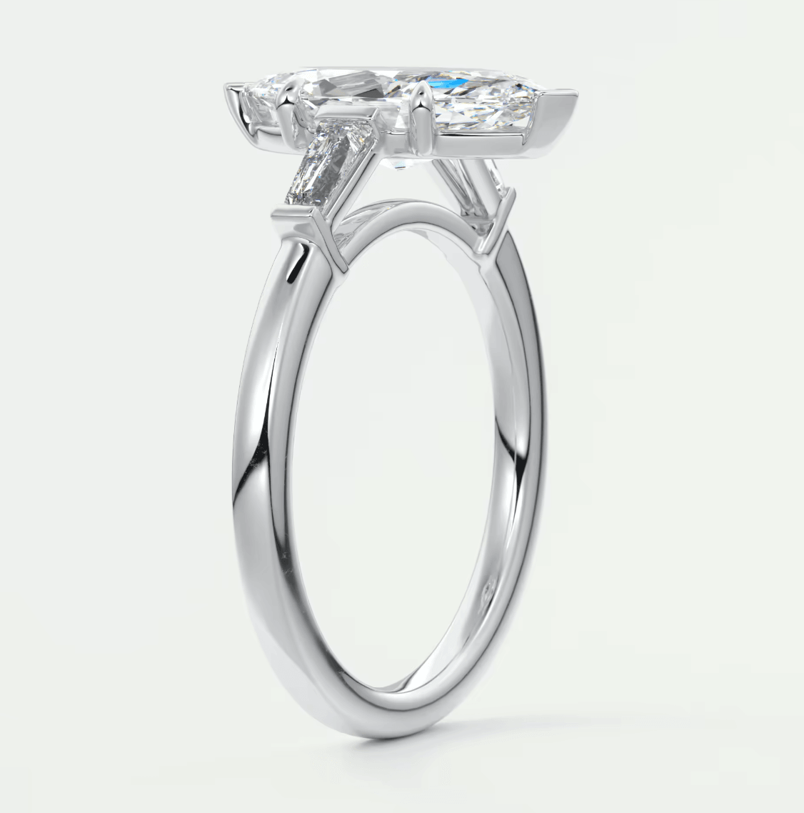 18-karat white gold engagement ring with a cushion-cut diamond center stone and baguette diamonds on the band.
